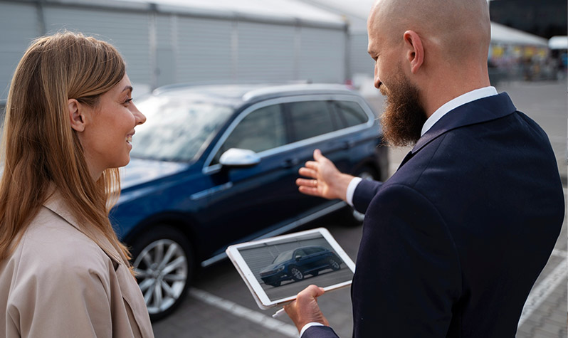 Woman talking to salesman while buying a new car