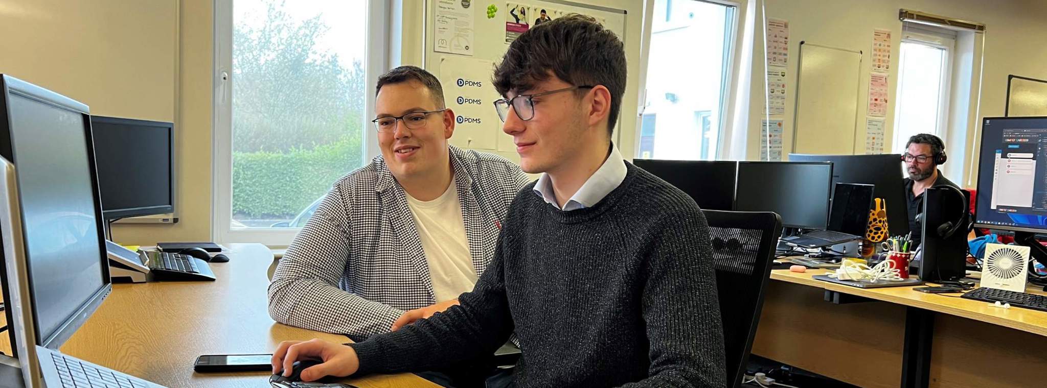 A photo of Nick and Regan working at their desks