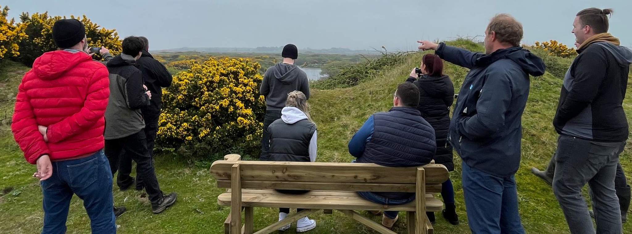 Group of people stood outside in a nature reserve looking out into the distance