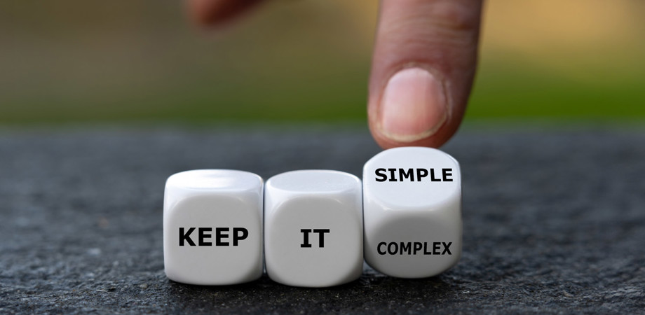 Hand turns dice and changes the expression 'keep it complex' to 'keep it simple'.