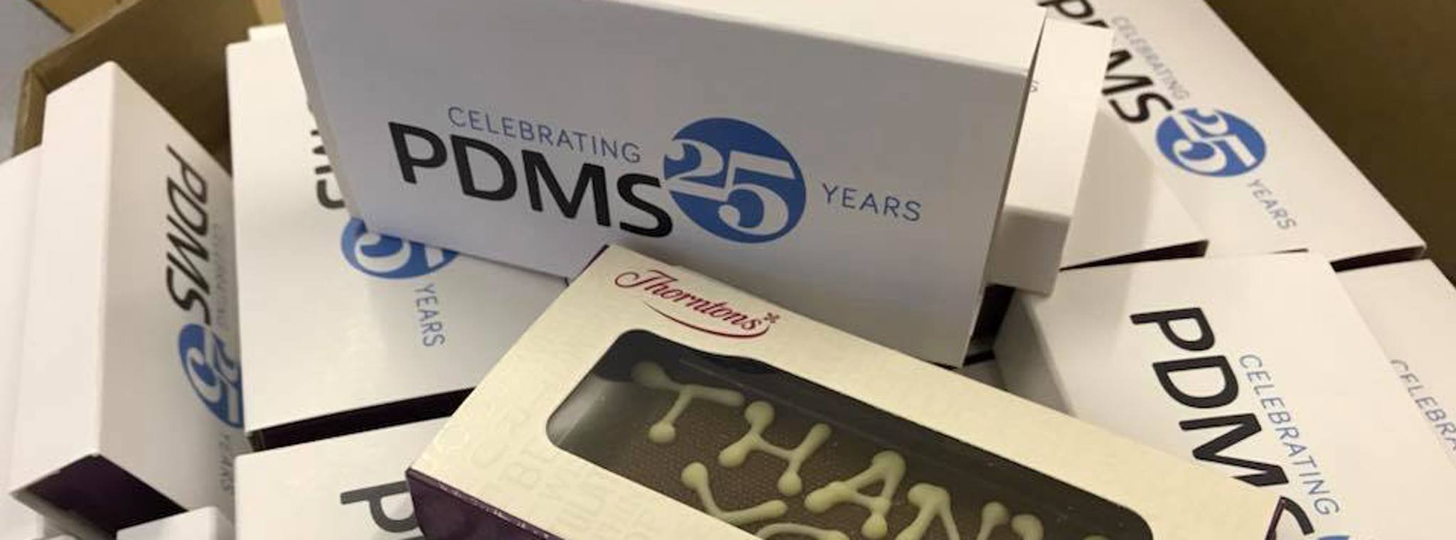 Photo of PDMS-branded chocolates in boxes that read 'Celebrating 25 years PDMS'