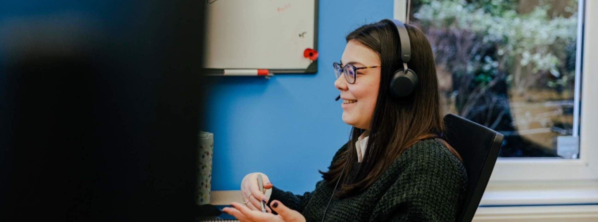 A photo of Katerina on a Teams call sat at her desk