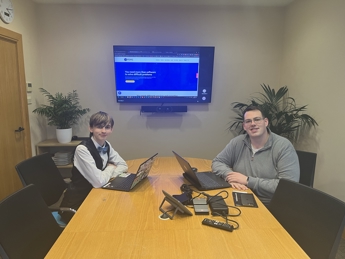 Nick Collins and Dagan Harris smiling for a photo in the PDMS boardroom