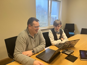 Nick Collins and Dagan Harris working on their laptops