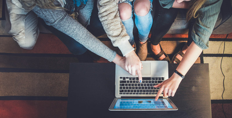 Close up of students looking at a laptop