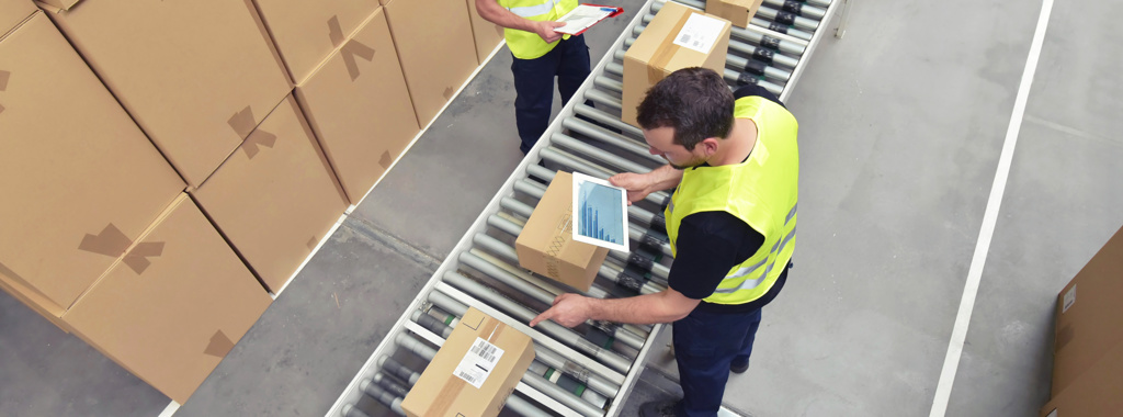 Two men working on a warehouse conveyor belt line checking parcels