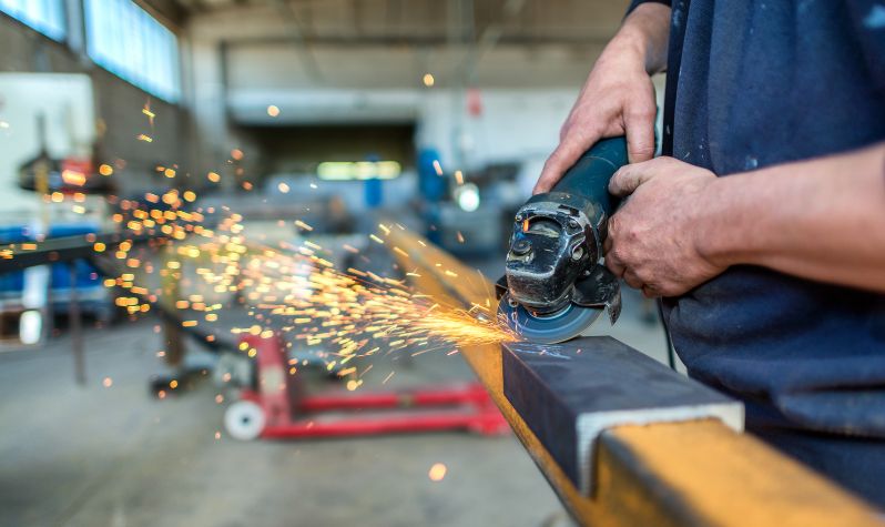 An image of an engineer using a tool with sparks flying off