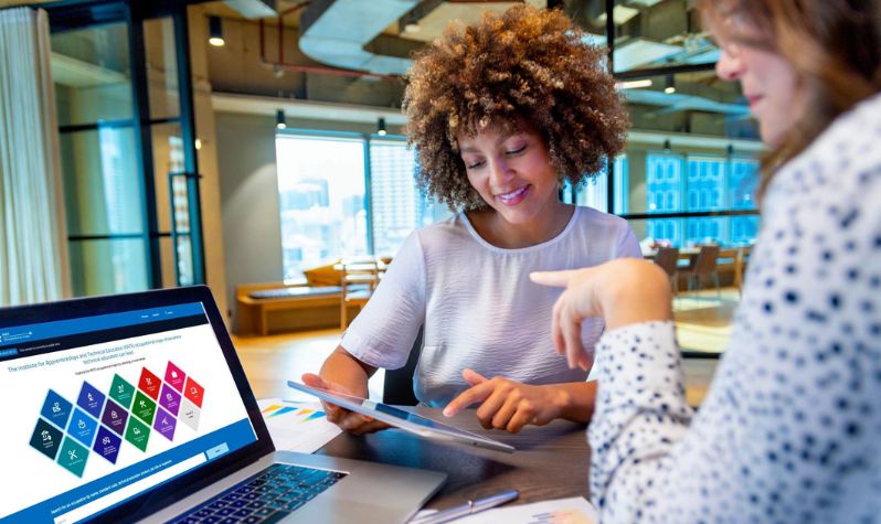 Two women with a laptop using IfATE Occupational Maps