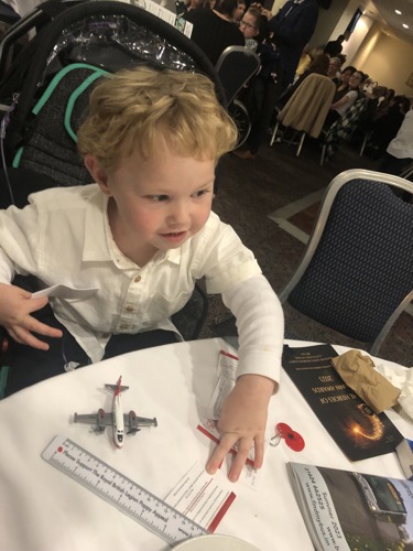 A photo of Aedan sat at a table at the Heroes of Mann Awards