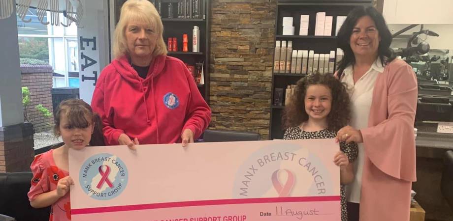 Saskia Edge and her sister presenting a cheque for £1440 to the Manx Breast Cancer Support Group