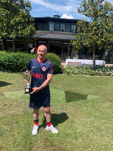 Stephen Falconer posing for a photo with a trophy in his EWFC kit