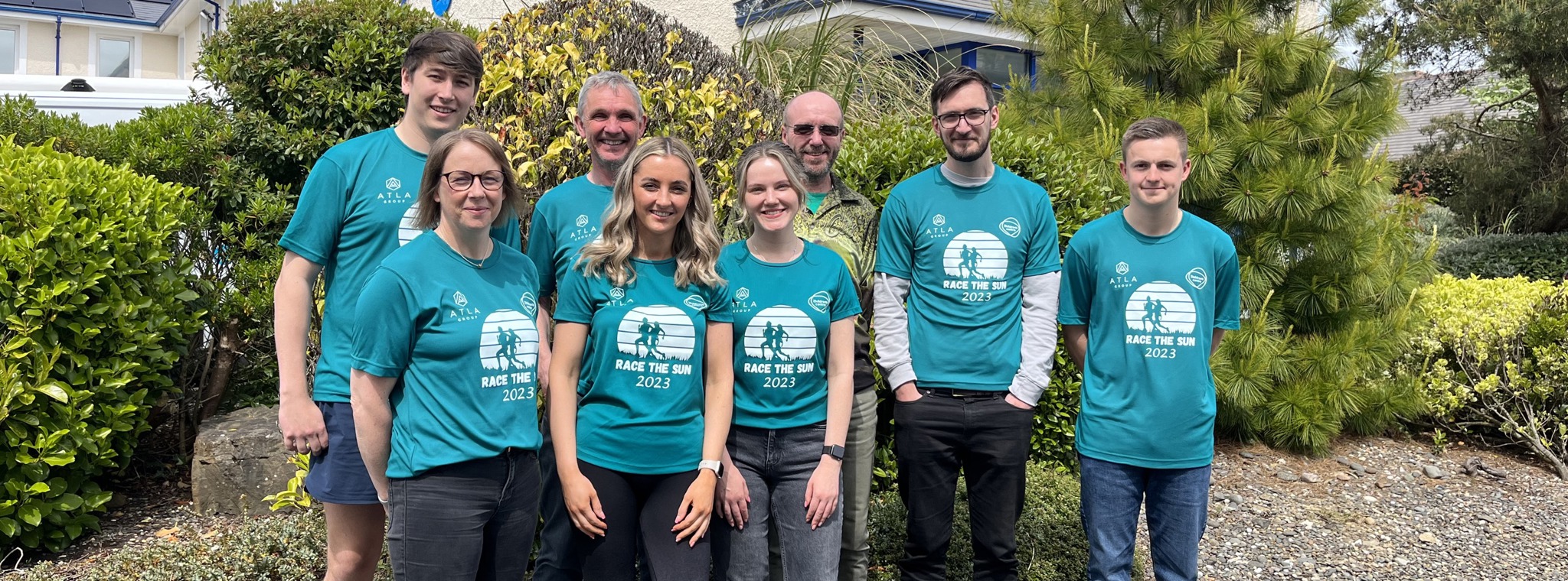 The PDMS team in matching Race the Sun sports t-shirts standing in front of the Isle of Man office