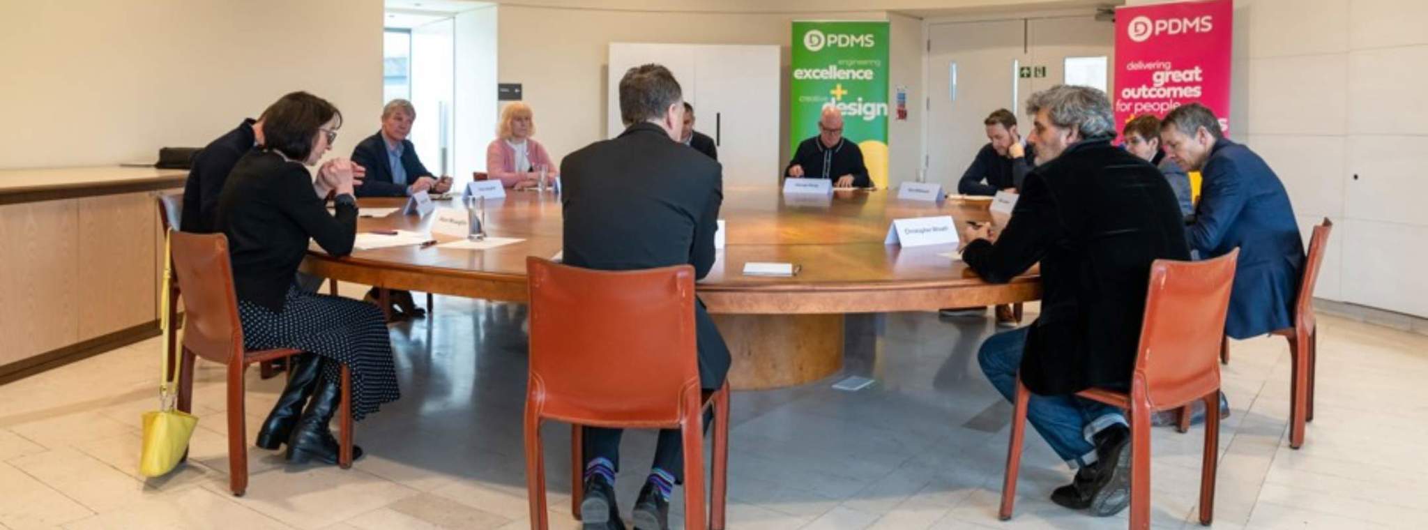 A photo of roundtable participants sat around a table having a discussion