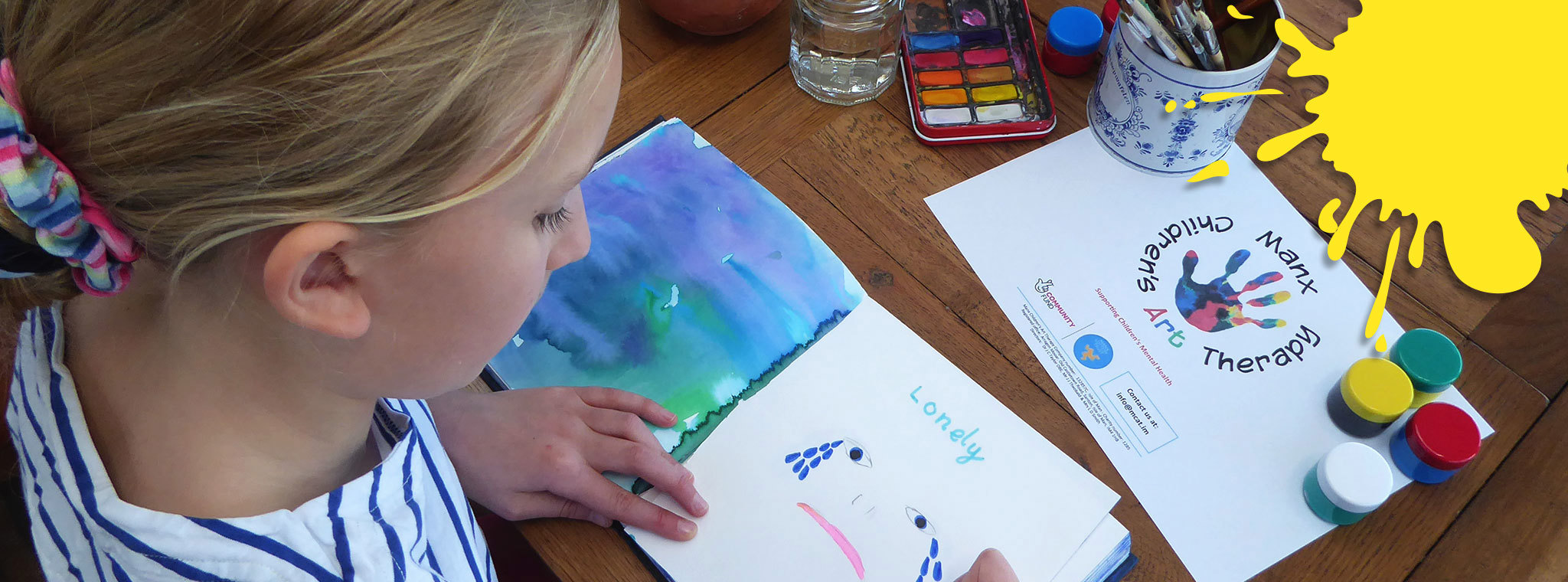 Girls painting with art materials to show how she feels 