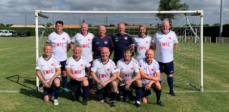 A photo of the England Walking Football Club team in two rows in front of the goals