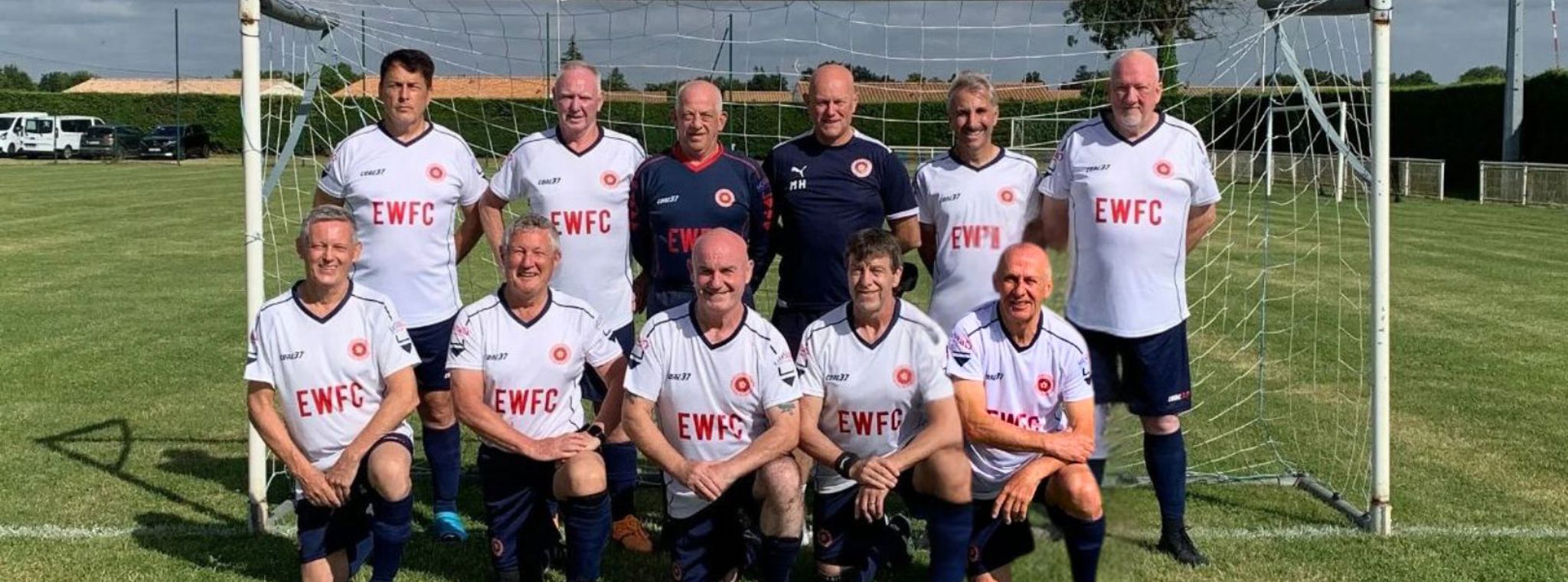 A photo of the England Walking Football Club team in two rows in front of the goals