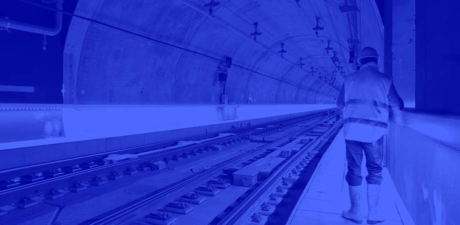 Duotone blue image of engineer working in a train tunnel 