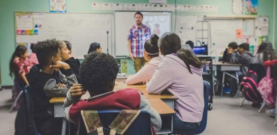 photo of school children and teacher in a class room