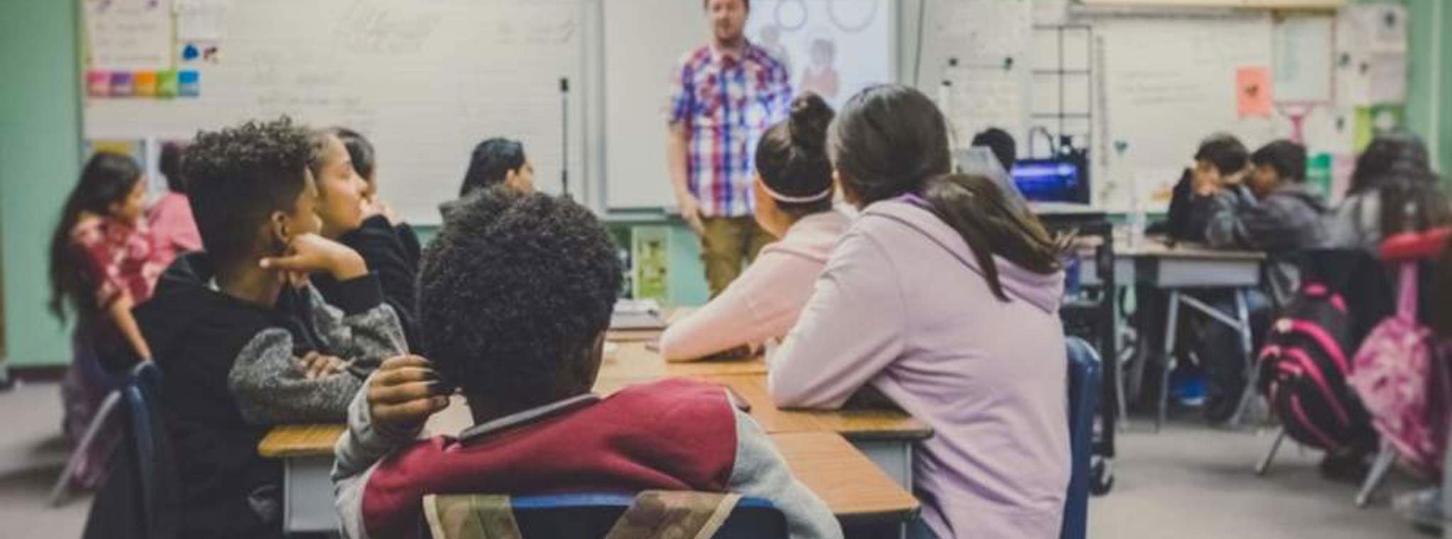 photo of school children and teacher in a class room